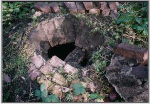 Hole in the semi-buried brick dome over shaft