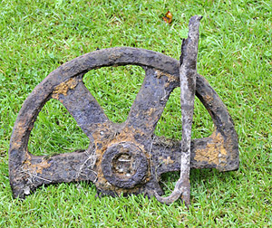 Artefacts found by the land owners while working in the garden. They appear to be part of a pulley wheel and the metal 'hook' end of a boat hook.